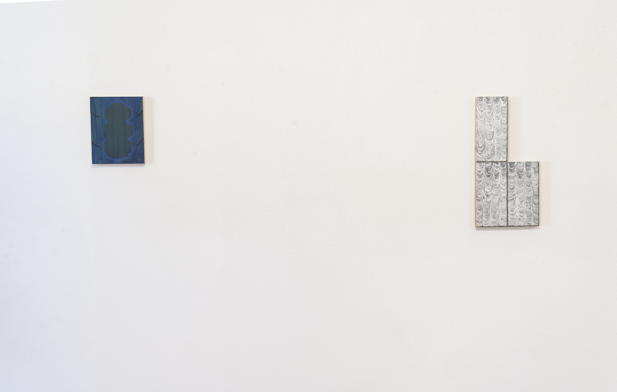 grey scale rectangular paintings on a white wall