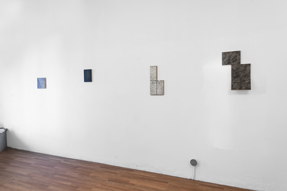 grey scale rectangular paintings on a white wall