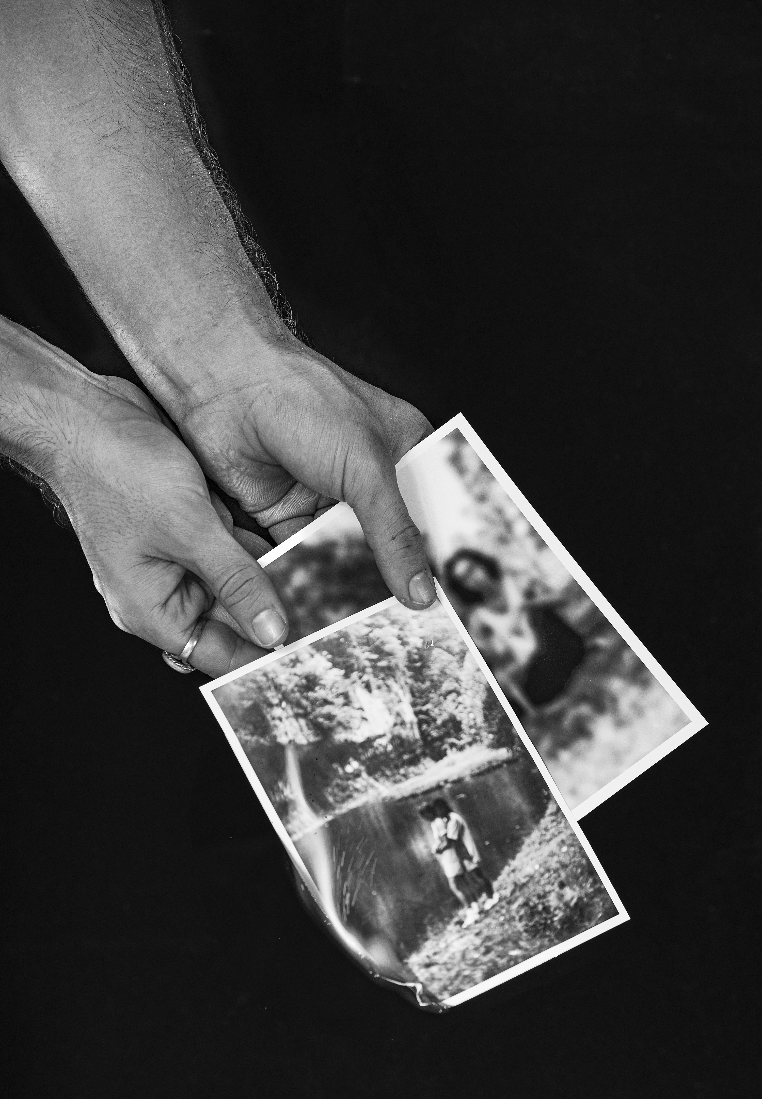 black and white photograph hands holding burning images